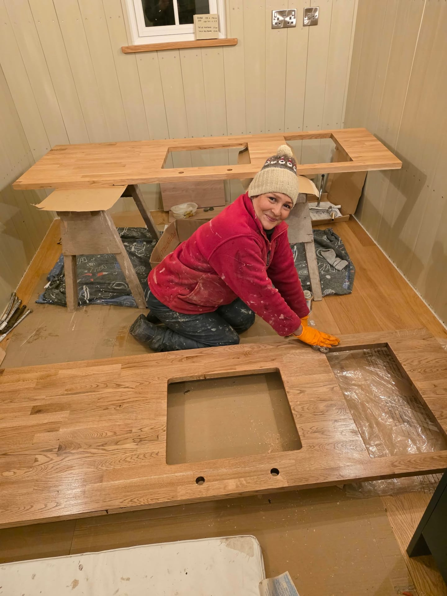 Eine Frau arbeitet im Inneren eines Waggons an Eichentischplatten für die Küche