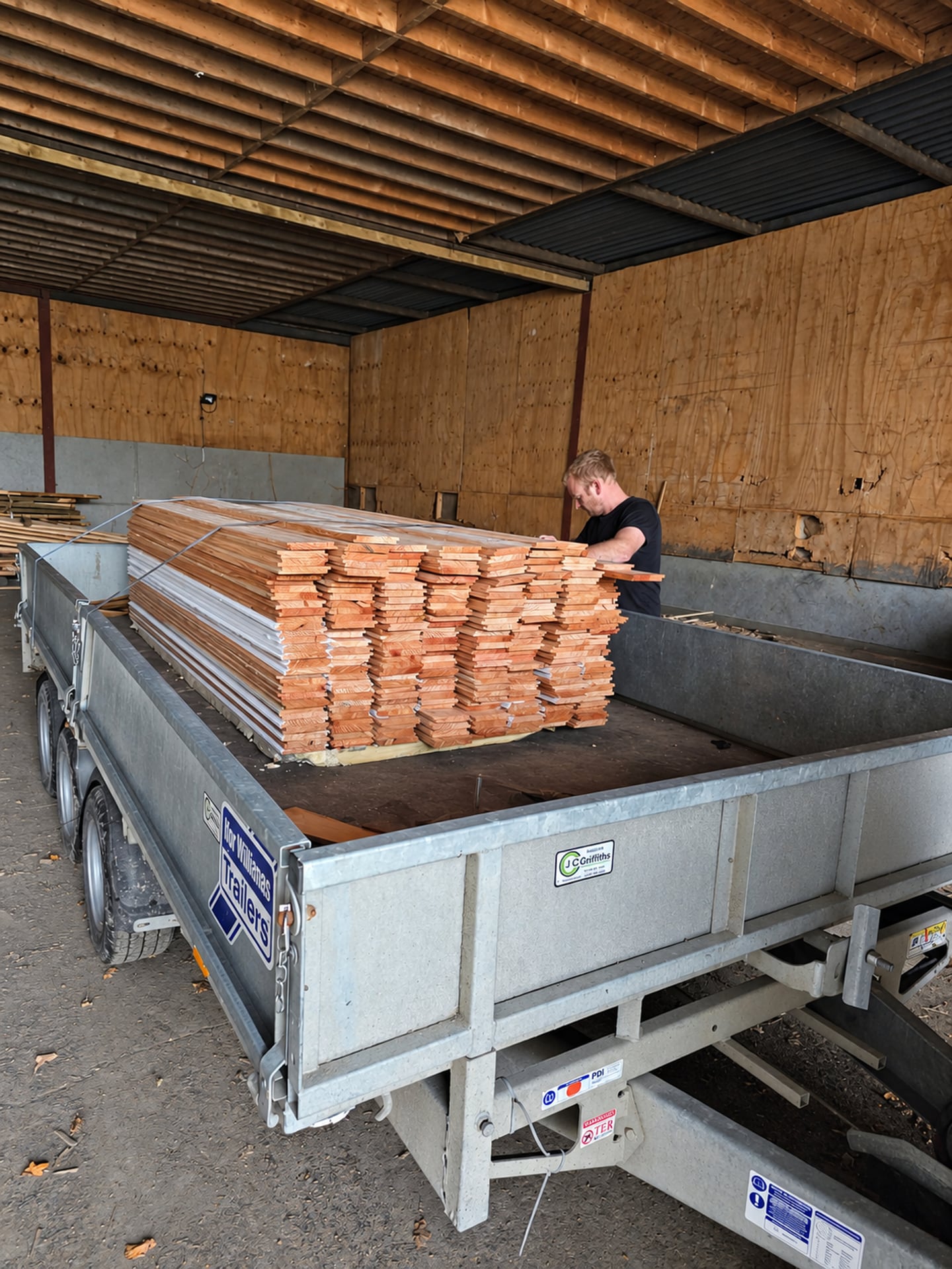 Frische Holzbretter auf einem Anhänger in der Werkstatt gestapelt